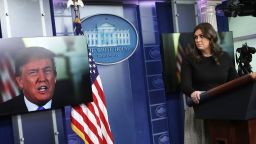 WASHINGTON, DC - JANUARY 04:  U.S. President Donald Trump speaks via a video as White House Press Secretary Sarah Sanders listens during a daily news briefing at the James Brady Press Briefing Room of the White House January 4, 2018 in Washington, DC. Sanders spoke on various topics including the new book "Fire and Fury",  written by Michael Wolff.  (Photo by Alex Wong/Getty Images)