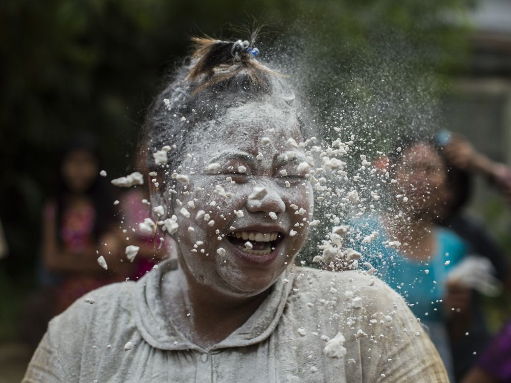 A woman plays a game with cake-making ingredients while taking part in Independence Day festivities in Yangon, Myanmar, on Thursday, January 4.