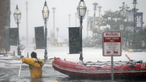 A firefighter wades through floodwaters from Boston Harbor on Long Wharf on Thursday.
