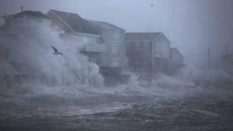 Waves crash against homes Thursday in Scituate, Massachusetts.