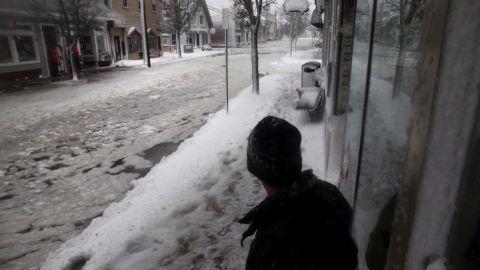 A man surveys a flooded street Thursday in Scituate, between Boston and Plymouth.