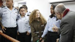 TOPSHOT - Palestinian Ahed Tamimi (C), 16-year-old prominent campaigner against Israel's occupation, appears at a military court at the Israeli-run Ofer prison in the West Bank village of Betunia on December 28, 2017. 
Ahed is only a teenager, but has repeatedly been at the centre of the seemingly endless propaganda war between Israelis and Palestinians, with a video of her slapping soldiers the latest example. / AFP PHOTO / Ahmad GHARABLI        (Photo credit should read AHMAD GHARABLI/AFP/Getty Images)