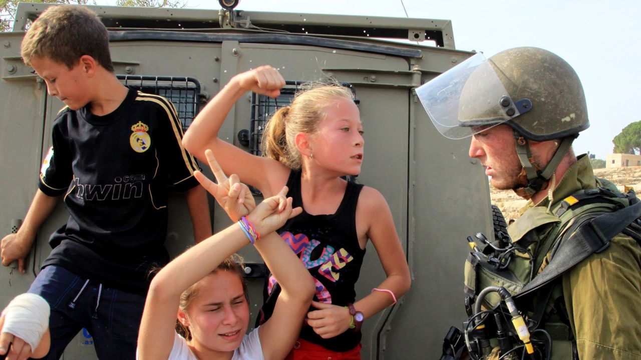 Ahed Tamimi (C) raises her fist to an Israeli soldier during a protest in Ramallah in 2012.