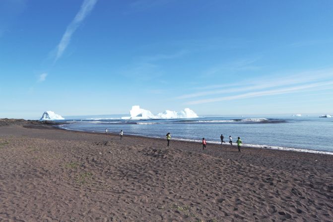 <strong>Splash down:</strong> Kids run down to the beach to play in the waves caused by a collapsing iceberg. 