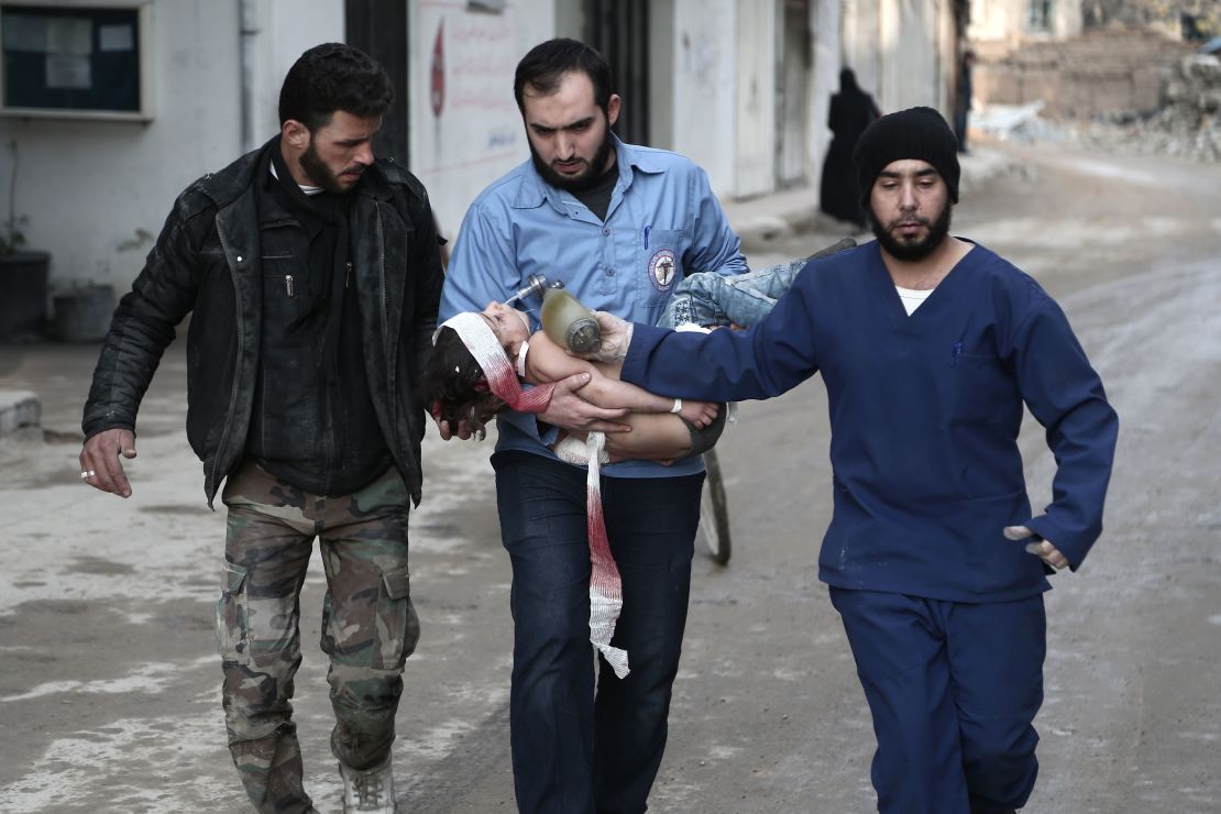 White Helmets volunteer rescuers carry a girl who was pulled from the rubble in Eastern Ghouta on January 6.