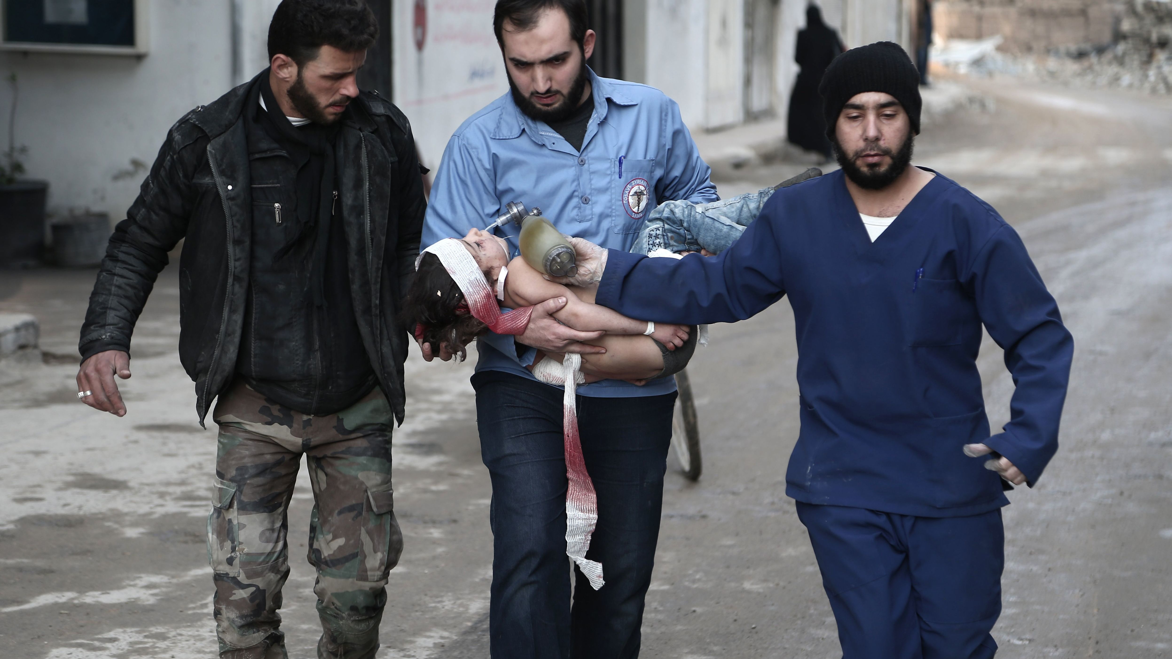 Rescuers from the volunteer White Helmets rescue group with a girl they pulled from the rubble following airstrikes in Eastern Ghouta, Syria, on Saturday. 