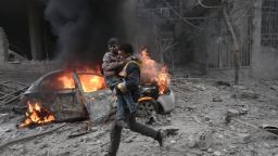 TOPSHOT - A Syrian paramedic carries an injured child following reported bombardment by Syrian and Russian forces in the rebel-held town of Hamouria, in the Eastern Ghouta, on January 6, 2018.
Regime and Russian air strikes on a rebel-held enclave near the Syrian capital killed at least 17 civilians, a war monitor said. / AFP PHOTO / ABDULMONAM EASSA        (Photo credit should read ABDULMONAM EASSA/AFP/Getty Images)