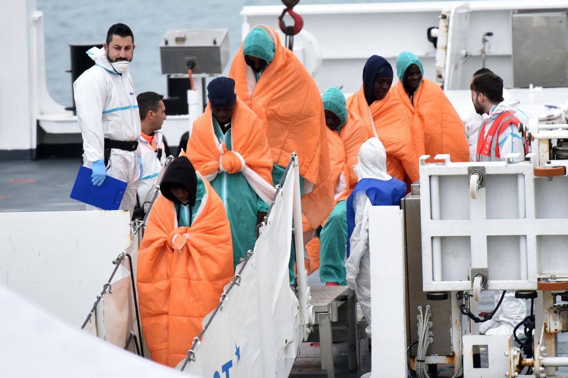 Migrants and refugees disembark from the Italian coast guard vessel "Diciotti" in the port of Catania following a rescue operation at sea.