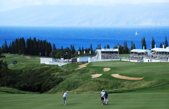 <strong>Into the blue: </strong>Dustin Johnson fires one towards the 18th green at Kapalua with the island of Moloka'i in the background. The powerful world No. 1 won the event by eight shots.