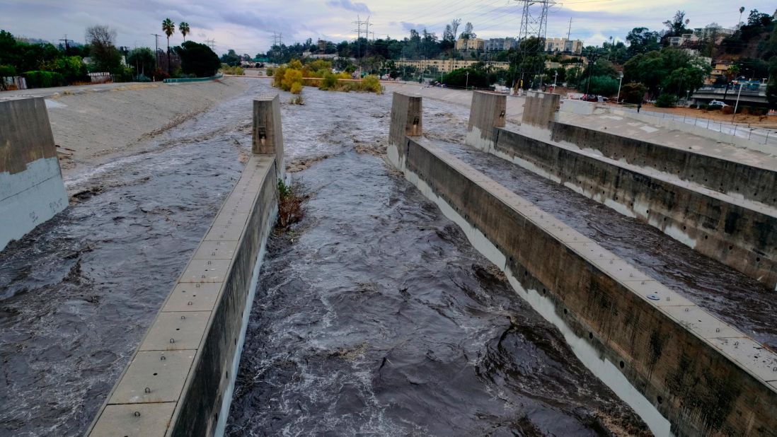 Rushing rainwater fills the Los Angeles River near downtown Los Angeles.