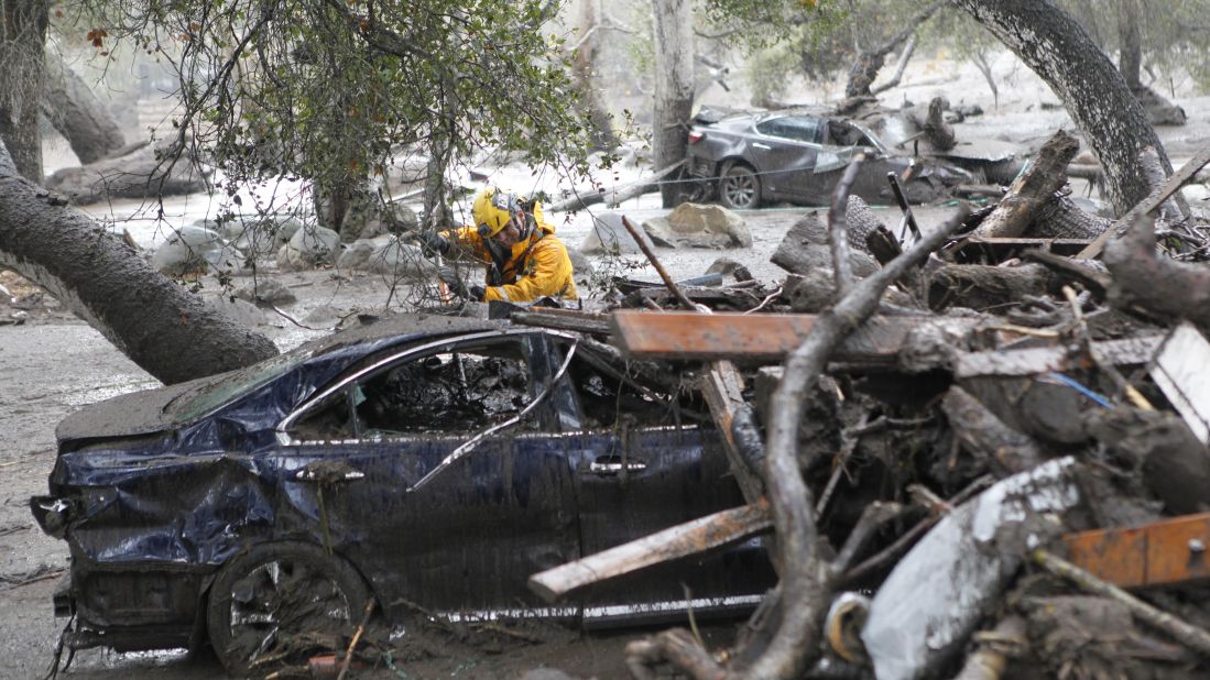 A member of the Long Beach search and rescue team looks for survivors in a car in Montecito on January 9, 2018.