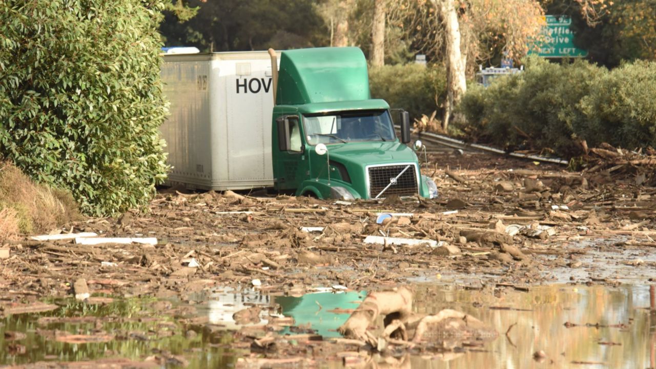 A tractor trailer in Southern California is stuck in mud and debris.
