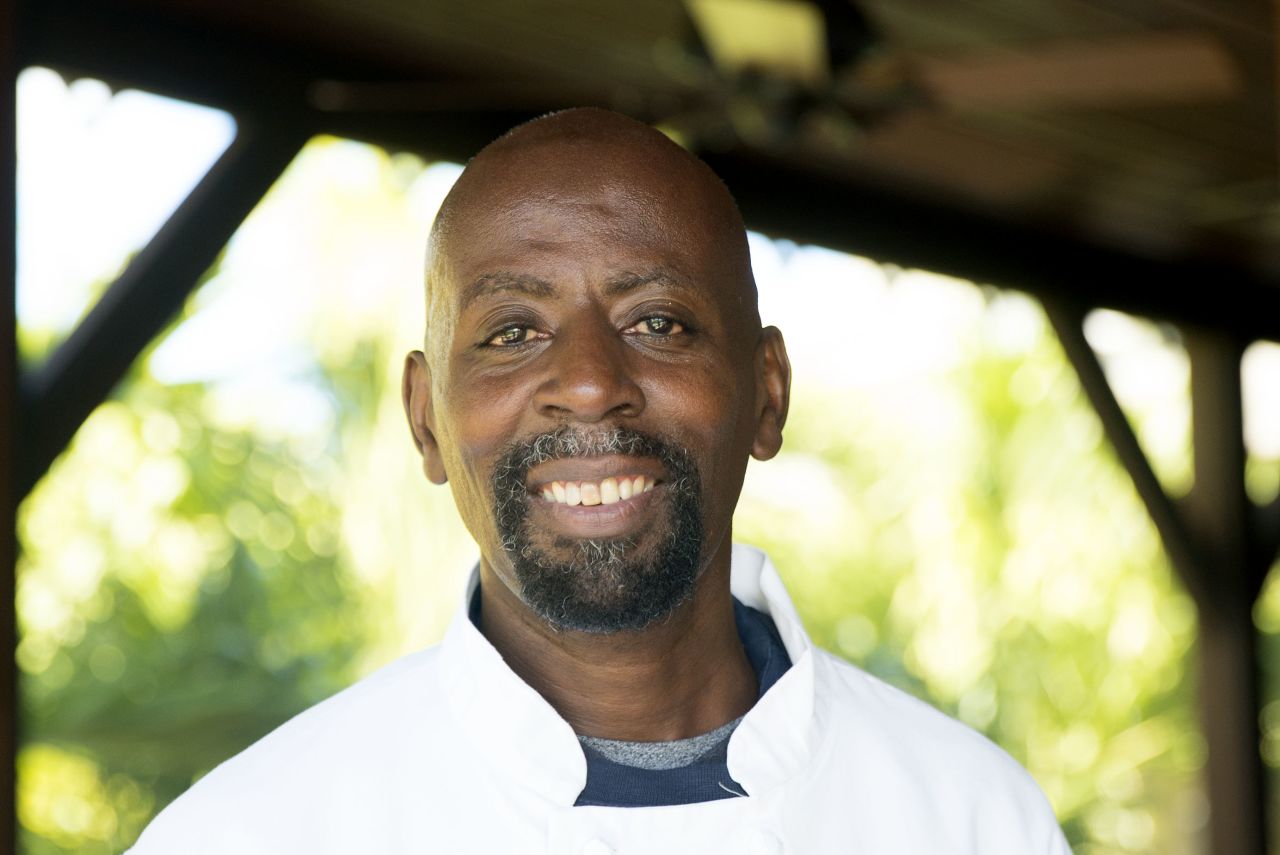 Llewellyn Clarke poses in front of his home in Nevis.