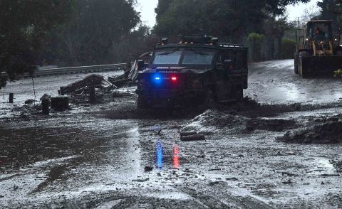 A police vehicle drives across a flooded side road in Montecito, near the San Ysidro exit of Highway 101 on January 9, 2018.