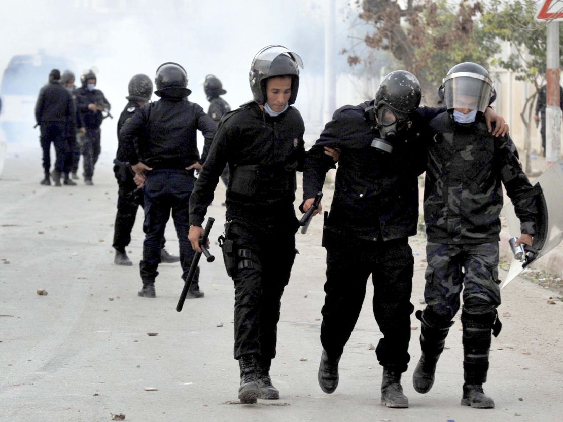 A wounded riot police officer is evacuated during anti-government protests in Tebourba, south of Tunis, on Tuesday.