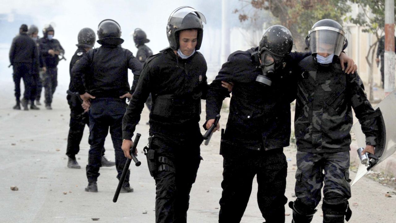 A wounded riot police officer is evacuated during anti-government protests in Tebourba, south of Tunis, on Tuesday.