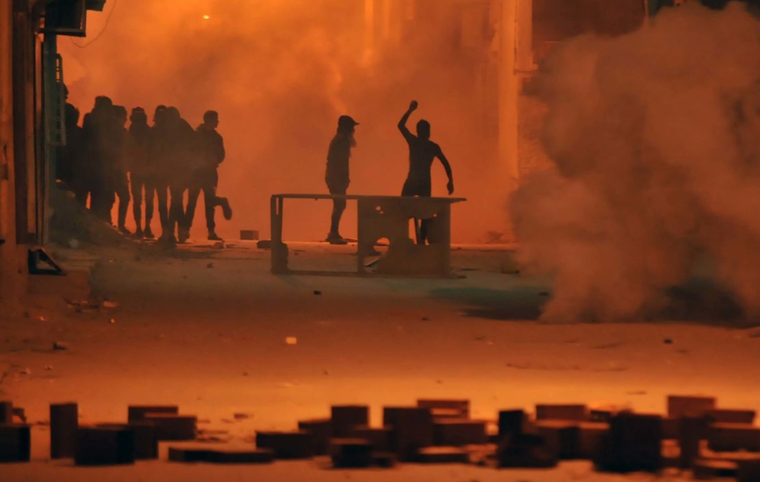 Protesters throw stones towards security forces in Tunis' Djebel Lahmer district early on Wednesday.