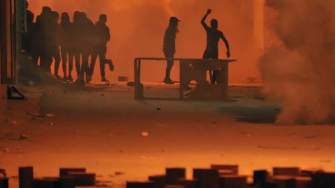 Protesters throw stones towards security forces in Tunis' Djebel Lahmer district early on Wednesday.