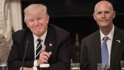US President Donald Trump smiles at a participant during an infrastructure summit with governors and mayors as Florida Governor Rick Scott (R) looks on in Washington, DC, on June 8, 2017. (NICHOLAS KAMM/AFP/Getty Images)