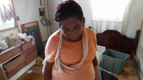 Carmen Rivera says she broke her arm sweeping water out of her living room.