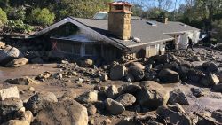 KERRY MANN navigates the large boulders and mudflow that destroyed the home of her friend in Montecito. The woman who lives in the home has not been seen since the early hours of Tuesday. At least 15 people died and thousands fled their homes in Southern California as a powerful rainstorm triggered flash floods and mudslides on slopes where a series of intense wildfires had burned off protective vegetation last month.