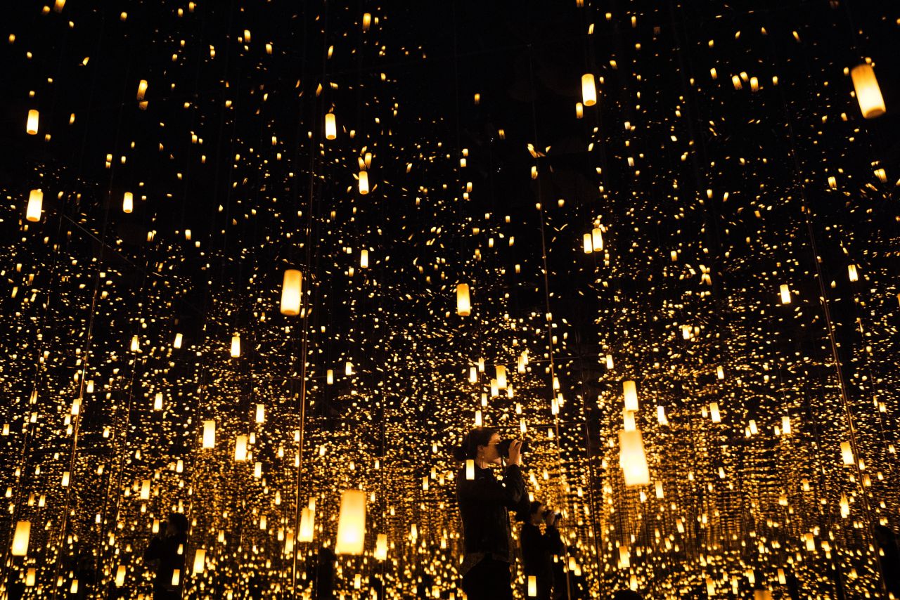 A woman photographs inside the Aftermath of Obliteration of Eternity room during a preview of the Yayoi Kusama's Infinity Mirrors exhibit at the Hirshhorn Museum (2017) in Washington, DC.