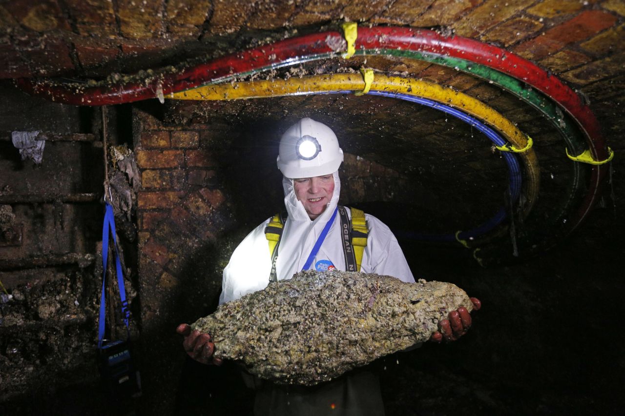 A sewer technician holds a fatberg in a London sewer in 2014.