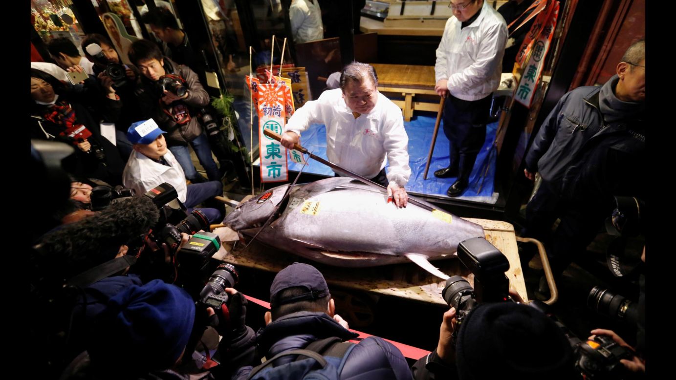Kiyoshi Kimura, president of a company that runs a sushi restaurant chain, poses with a massive bluefin tuna at the Tsukiji Market in Tokyo on Friday, January 5. The tuna weighed 190 kilograms (419 pounds).
