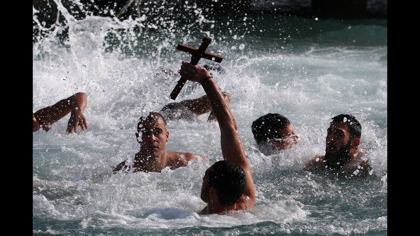 A man holds a cross during a competition to retrieve it from the water during Epiphany celebrations in Zygi, Cyprus, on Saturday, January 6.