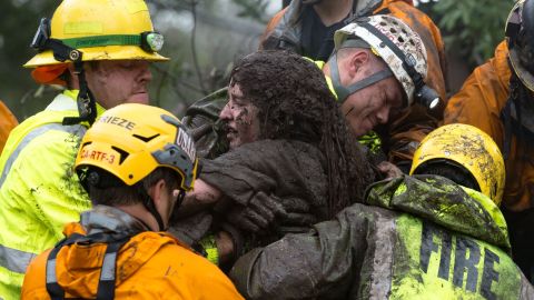 Emergency personnel carry a woman from a collapsed house after a mudslide in Montecito on January 9, 2018. 