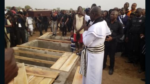 Priest administers burial rites at the mass burial