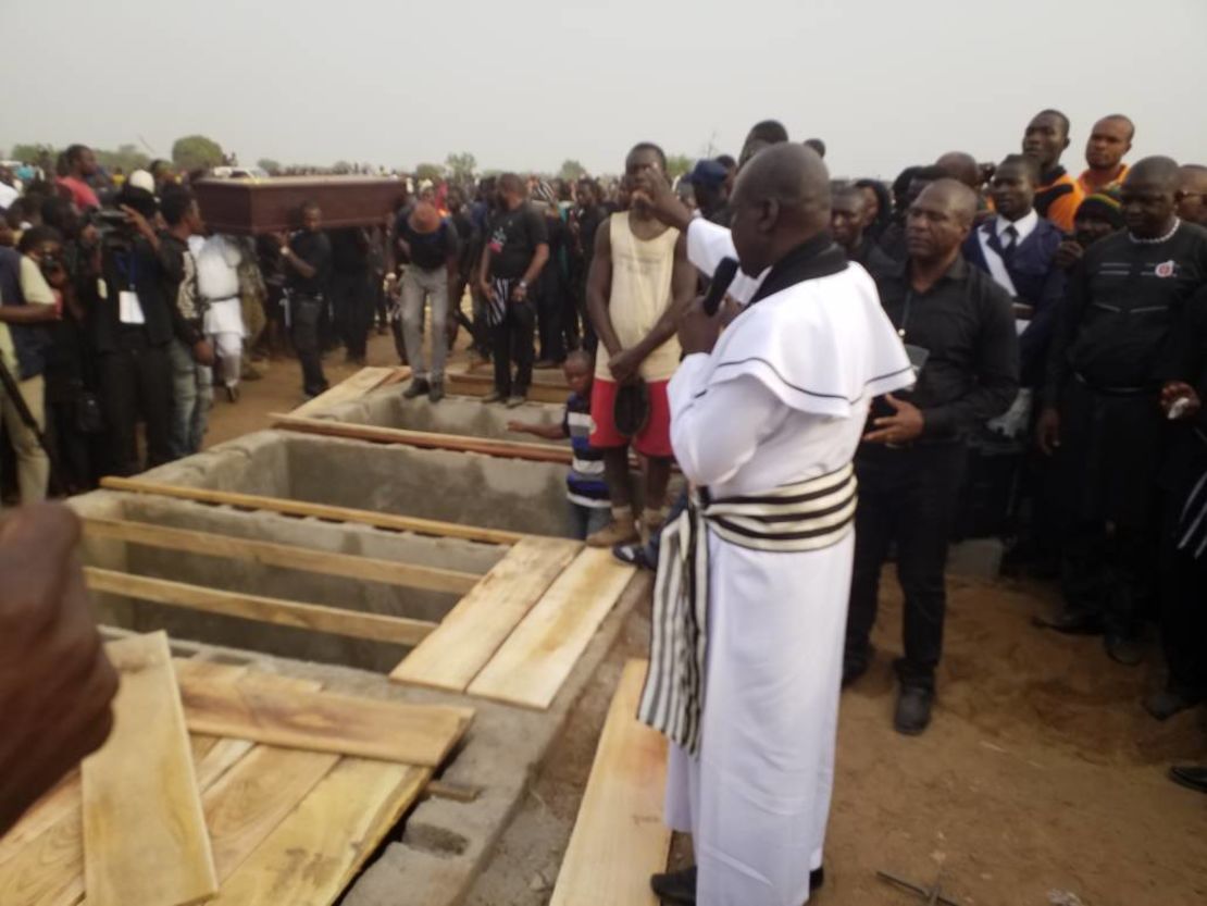 Priest administers burial rites at the mass burial