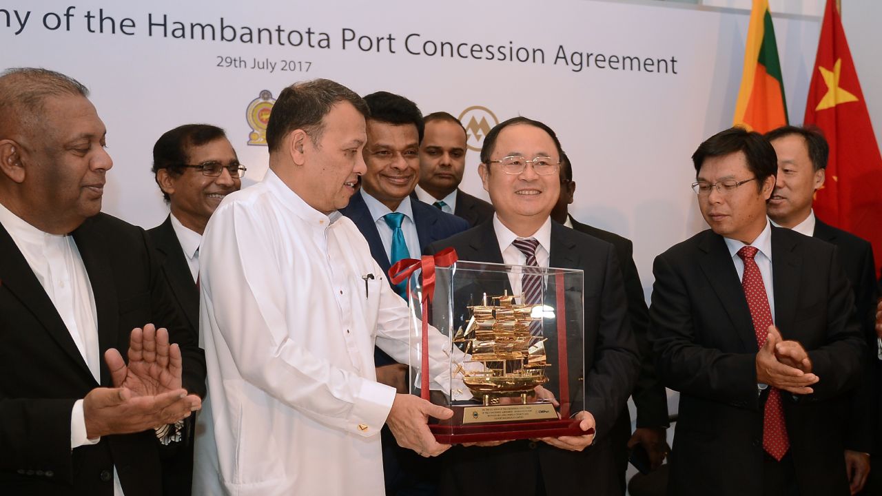 Sri Lanka's Minister of Ports & Shipping Mahinda Samarasinghe exchanges souvenirs during the Hambantota International Port Concession Agreement at a signing ceremony in Colombo in 2017. 