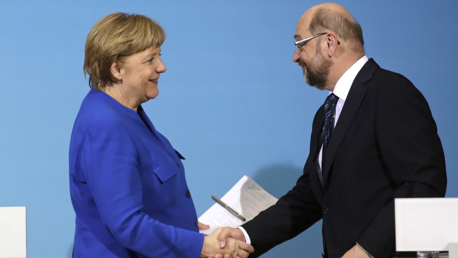Merkel (L) shakes hands with Martin Schulz during a joint statement after talks on Friday.