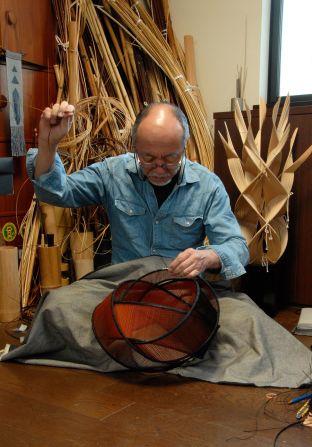 Japanese artist Fujitsuka Shosei works on bamboo basket in his studio