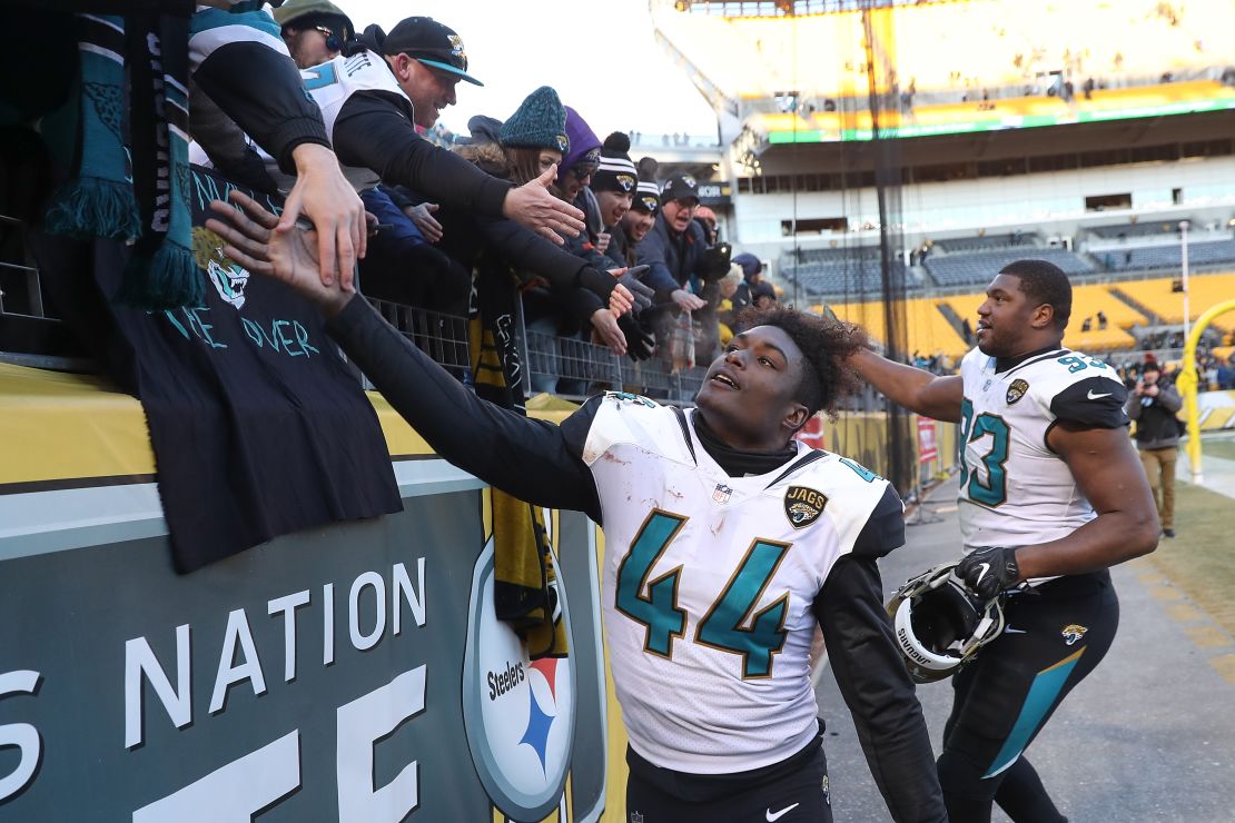 Myles Jack and Calais Campbell of the Jaguars high five fans after defeating the Steelers.