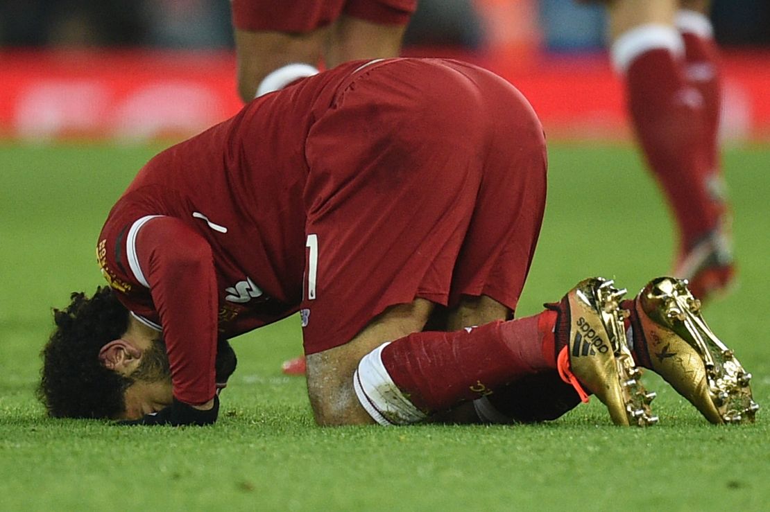 Liverpool's Egyptian midfielder Mohamed Salah puts his head on the pitch after scoring his team's fourth goal.