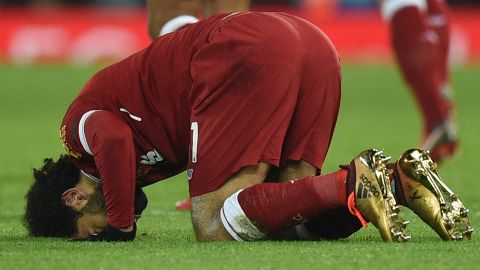 Liverpool's Egyptian midfielder Mohamed Salah puts his head on the pitch after scoring his team's fourth goal.