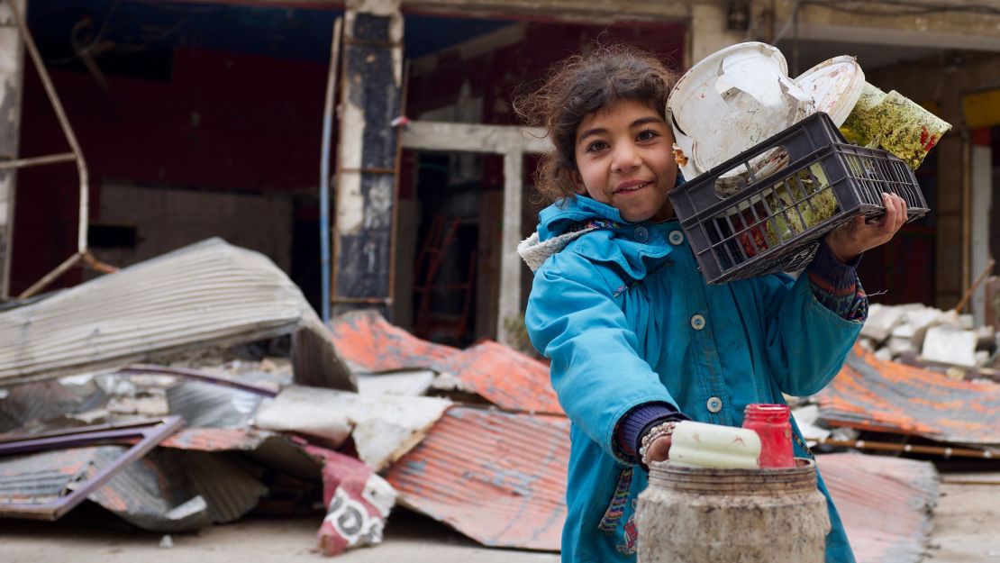 A young girl in the town of Maraat Nouman with her haul for the day. She's just finished picking through the garbage around the site of a recent airstrike for reusable plastic.