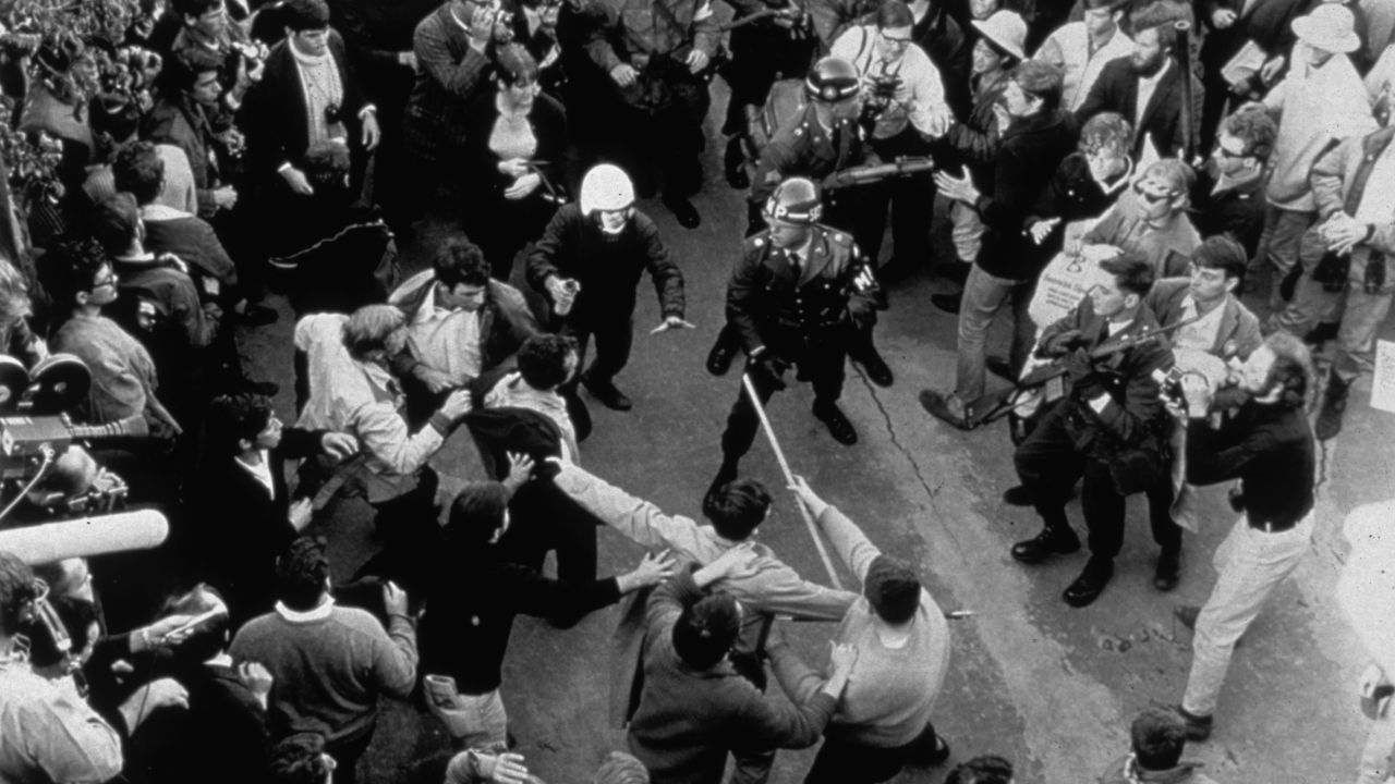 A policeman with mace spray confronts crowd of anti-Vietnam war protesters in 1968.