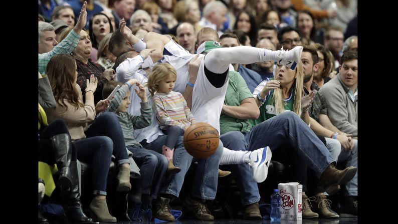 Fans brace as Dallas Mavericks' J.J. Barea lands in their laps while chasing a loose ball at an NBA basketball game against the Orlando Magic on Tuesday, January 9.<br />