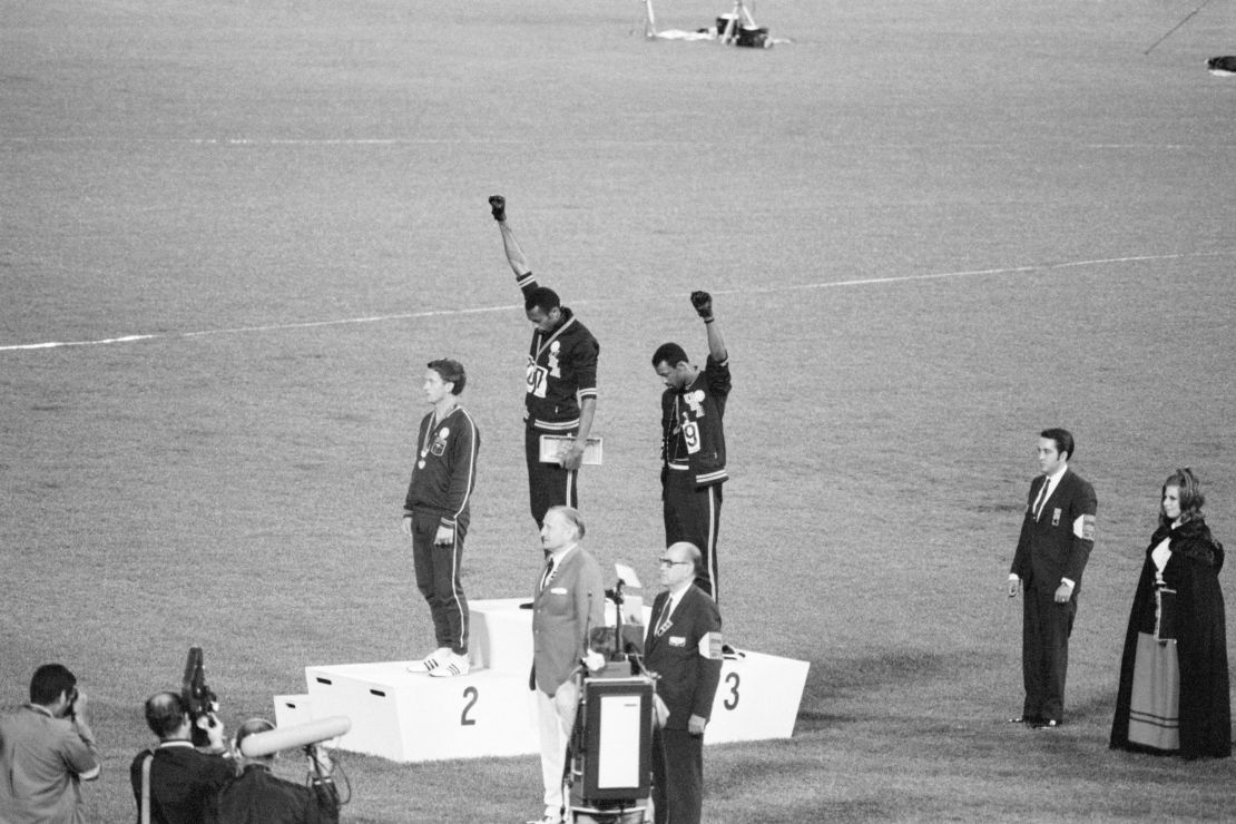 Tommie Smith, center, and John Carlos, gold and bronze medalists in the 200-meter sprint at the 1968 Olympic Games, raise their fists on the medal stand. 