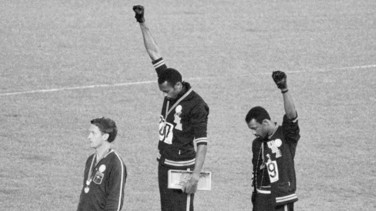 Tommie Smith, center, and John Carlos, gold and bronze medalists in the 200-meter sprint at the 1968 Olympic Games, raise their fists on the medal stand. 