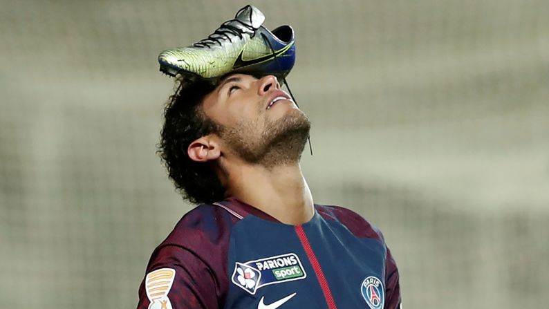 Paris Saint-Germain's Neymar balances his boot on his head to celebrate scoring a penalty kick during the French League Cup quarter-final football match on January 10 in Amiens, northern France.