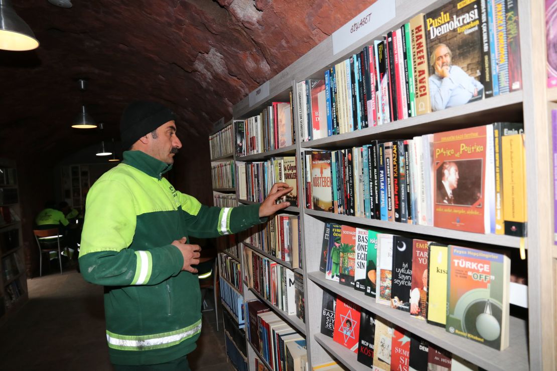 A garbage collector in Ankara browses for books at the library.