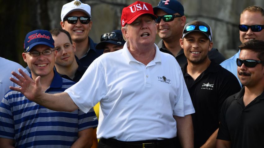 US President Donald Trump speaks to service members of the United States Coast Guard during an invitation to play golf at Trump International Golf Course in Mar-a-Lago, Florida on December 29, 2017.
The President invited members of the Coast Guard to play golf to thank them personally for their service of patrolling the waters near Palm Beach and Mar-a-Lago. / AFP PHOTO / Nicholas Kamm        (Photo credit should read NICHOLAS KAMM/AFP/Getty Images)