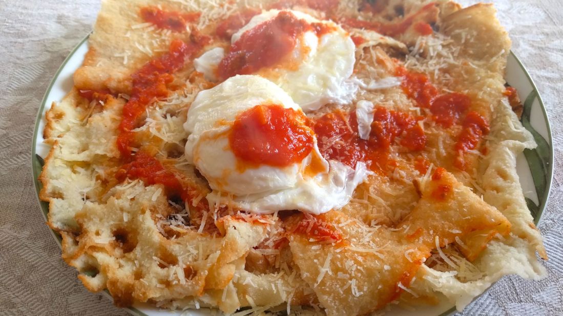 <strong>Local cuisine: </strong>Su pane vratau, made of multi-layers of flat crispy carasau bread soaked in water, tomato sauce, poached eggs and grated Fiore sheep cheese, is one of Ollolai's top dishes.