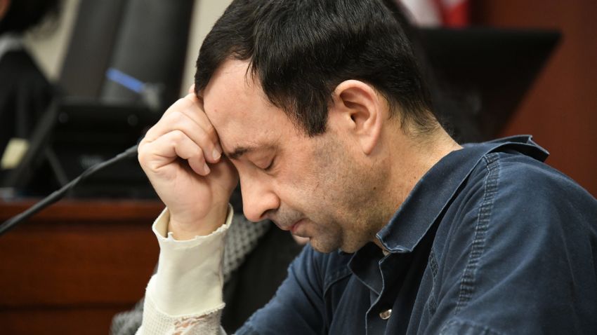 A victim makes her "impact statement" to Larry Nassar during a sentencing hearing as he puts his head down in front of Judge Rosemarie Aquilina in district court on Tuesday, Jan. 16, 2018, in Lansing, Mich. Nassar has pleaded guilty to molesting females with his hands at his Michigan State University office, his home and a Lansing-area gymnastics club, often while their parents were in the room. (Dale G. Young/Detroit News via AP)