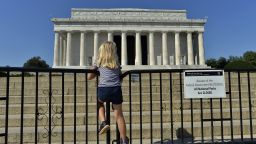 A child stands on the barricade around the Lincoln Memorial in Washington, DC, on October 2, 2013, on the second day of the federal government shutdown. US President Barack Obama on Wednesday called congressional leaders to a White House meeting, providing a glimmer of hope for movement on day two of a crippling government shutdown. The White House is squaring off with Republican rivals in Congress over how to fund federal agencies, many of which are now closed, leaving some 800,000 furloughed workers in the lurch and a fragile economy at risk. AFP Photo/Jewel Samad        (Photo credit should read JEWEL SAMAD/AFP/Getty Images)