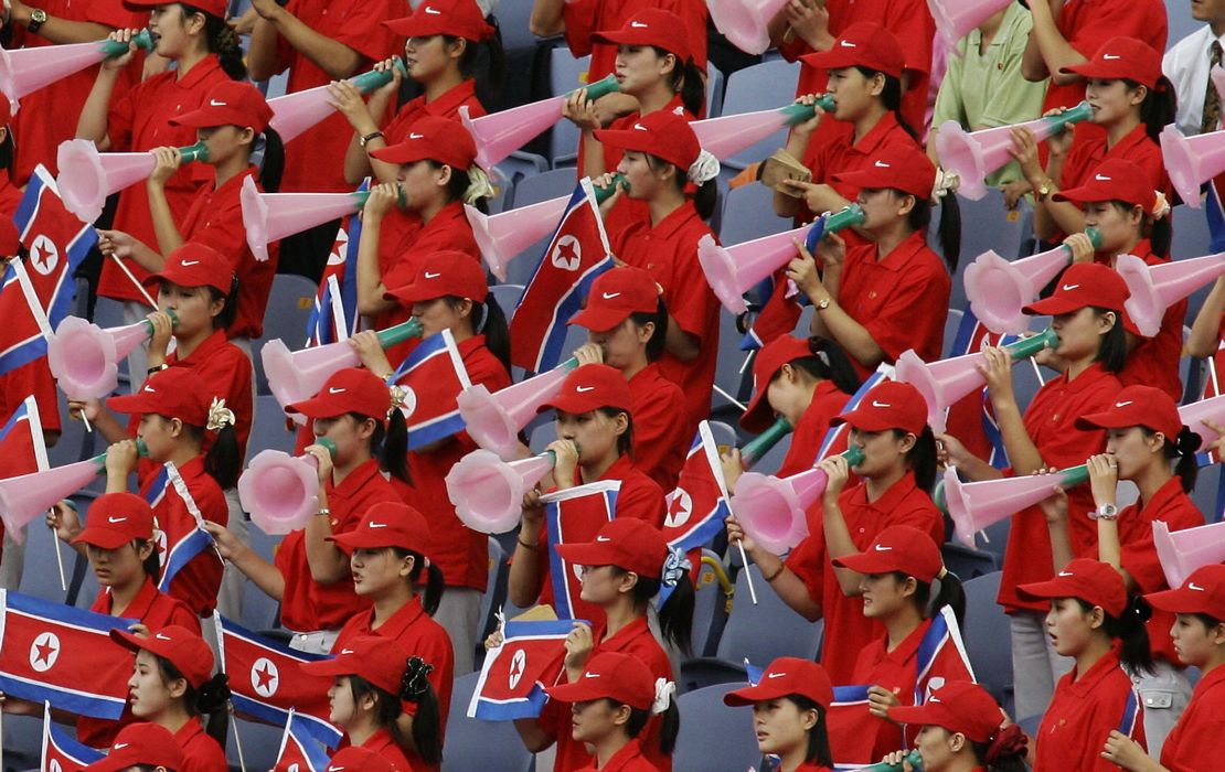North Korean cheering squad hold their national flag and cheer 04 September 2005.